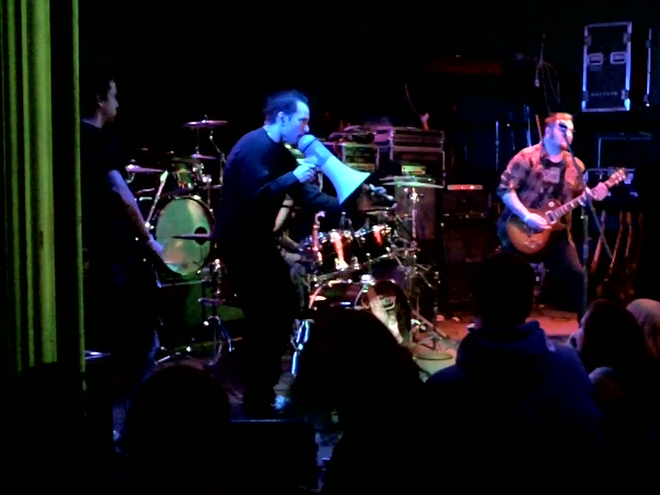 Josh Holland fronting his band Karmedy on stage